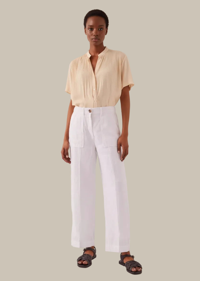 Person wearing white pants on a plain background