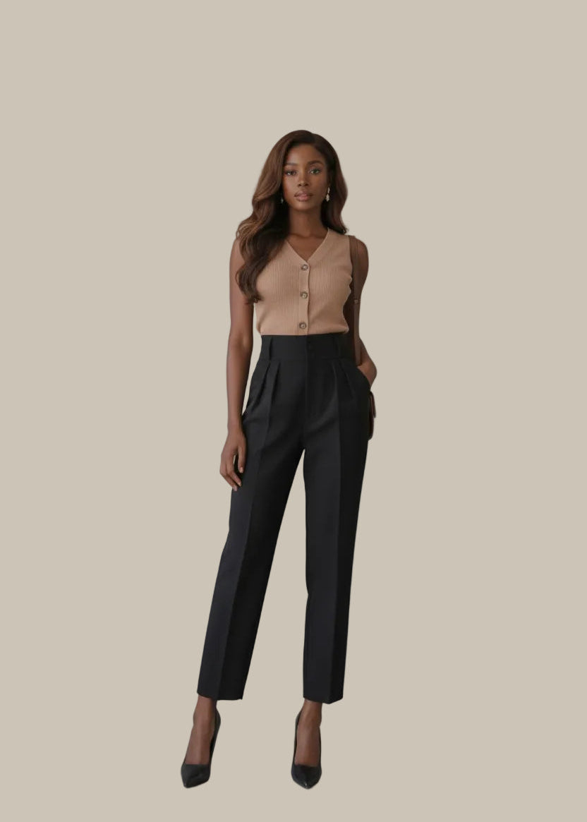 Person wearing a beige top and black pants in a room with a Loewe bag and decorative items.