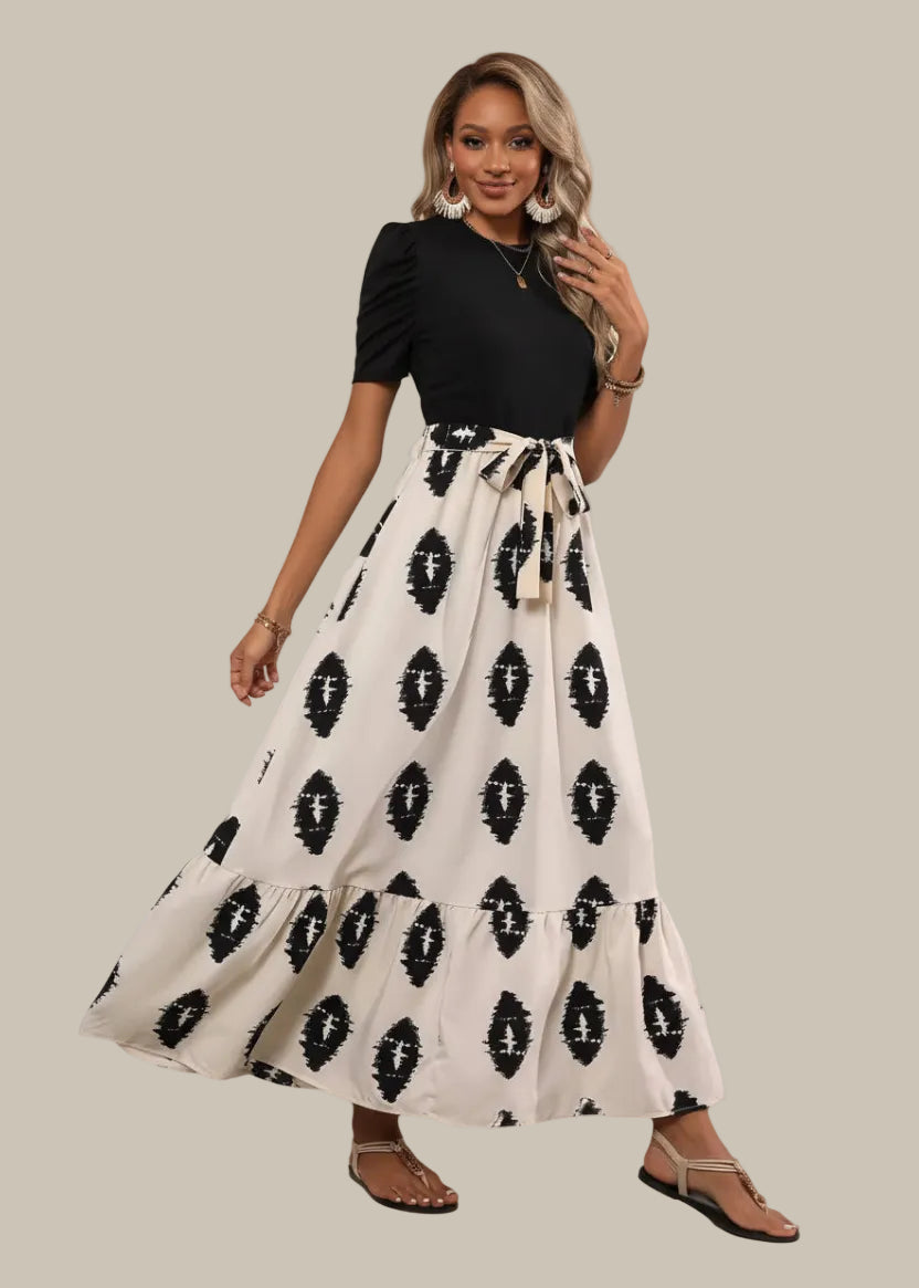 Woman wearing a black top and white skirt with black patterns on a white background