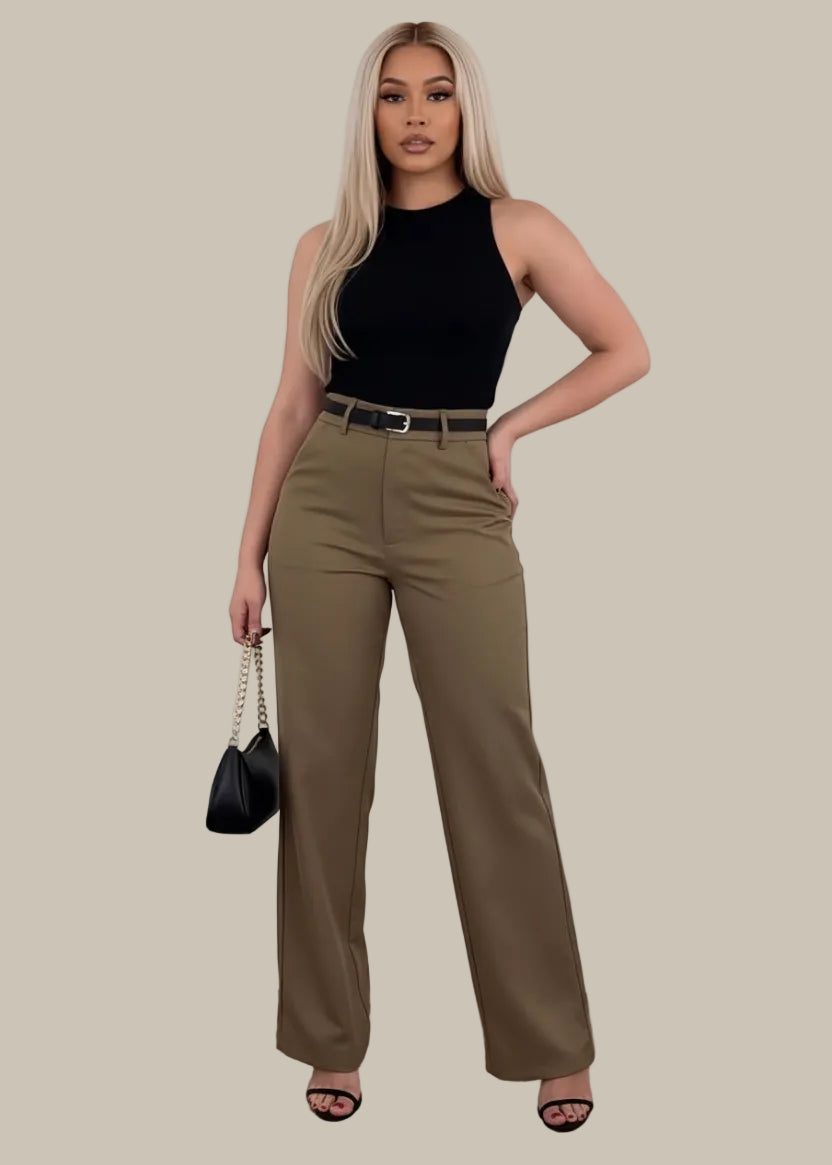 Person wearing brown pants with a black handbag on a wooden floor.