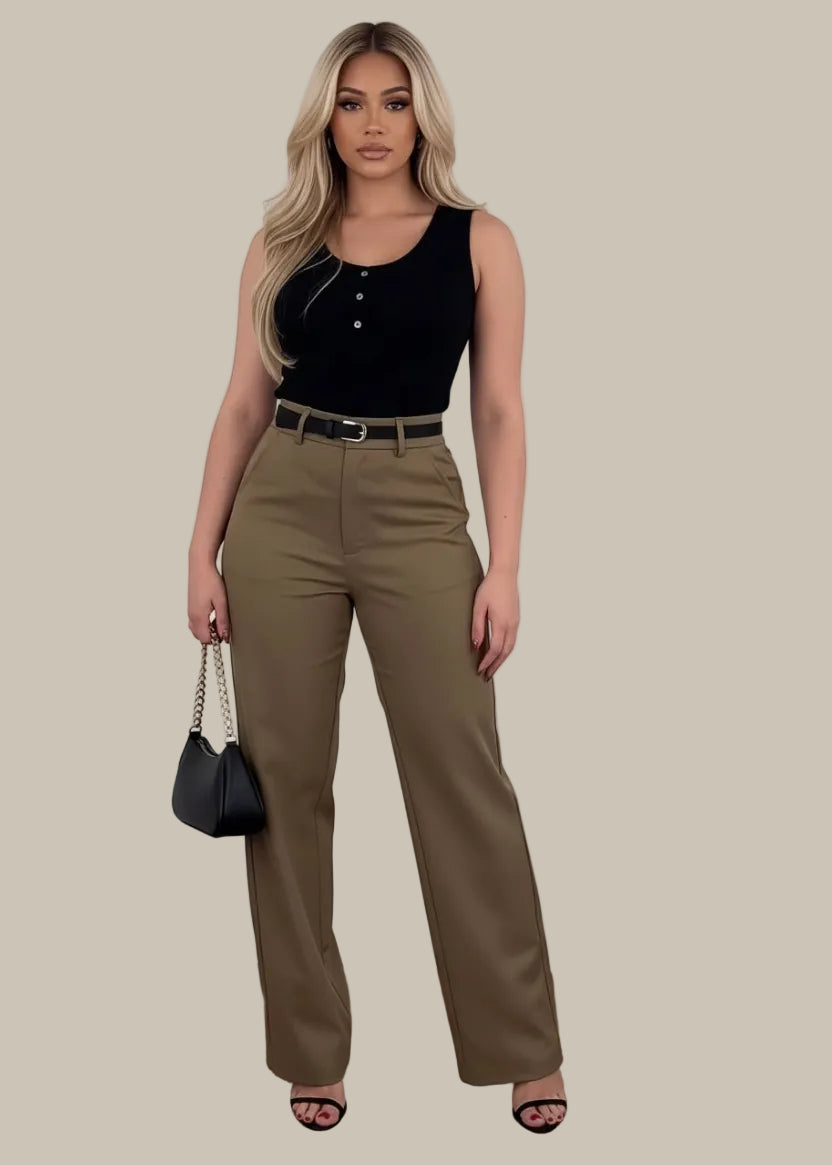 Person wearing brown pants with a black handbag on a wooden floor.