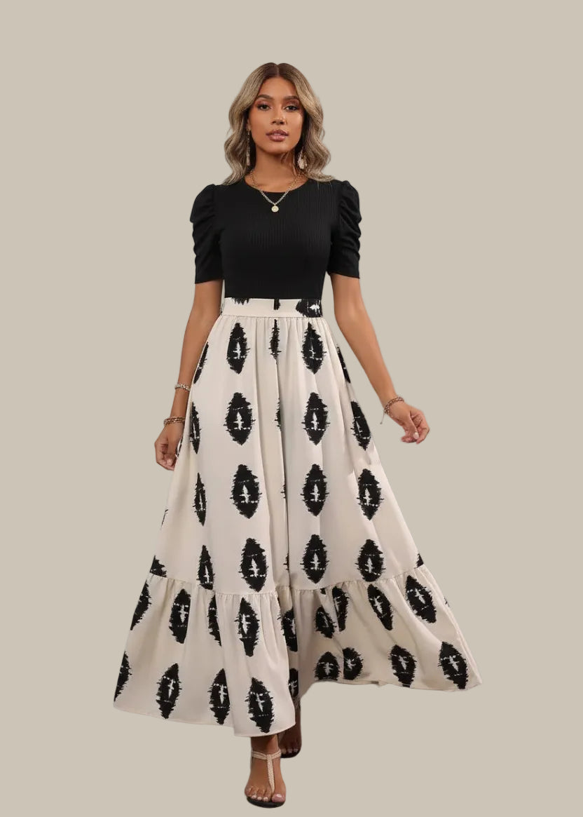 Woman wearing a black and white patterned skirt on a wooden deck.