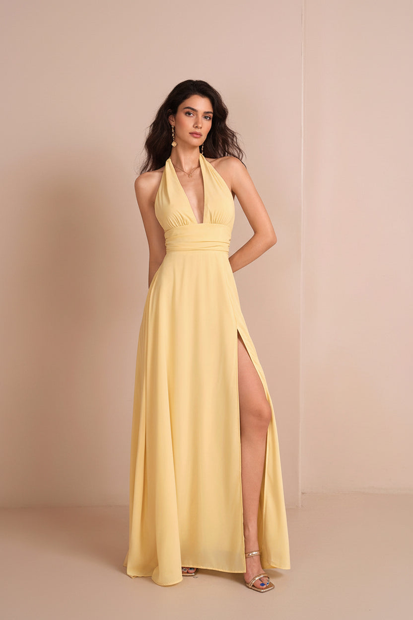 Yellow evening gown with a high slit on a beige background