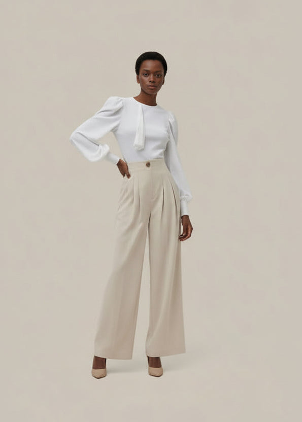 Woman wearing a white blouse and beige pants on a beige background