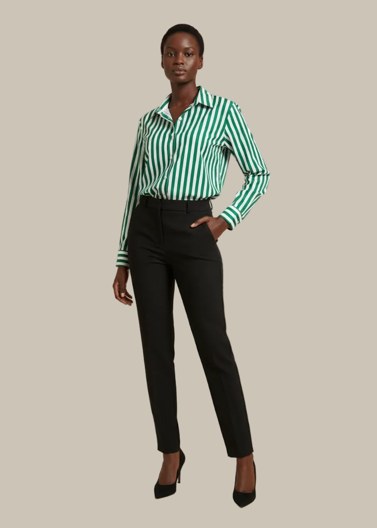 Woman wearing a green and white striped shirt with black pants on a beige background
