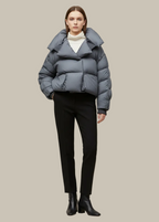 Person wearing a blue puffer jacket on a beige background
