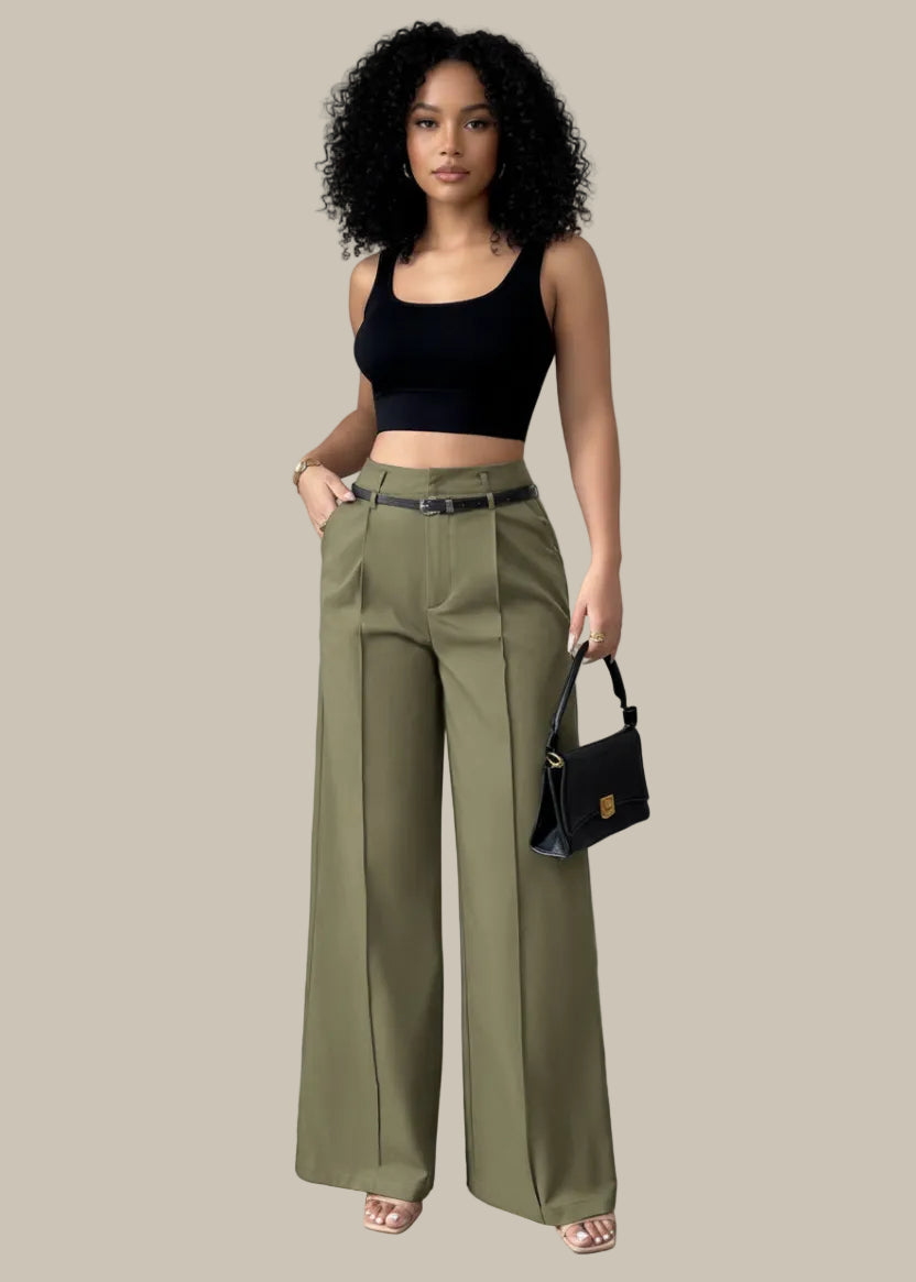 Person wearing olive green wide-leg pants with a black top and handbag against a neutral background