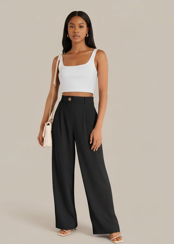 Woman wearing a white top and black pants against a beige background