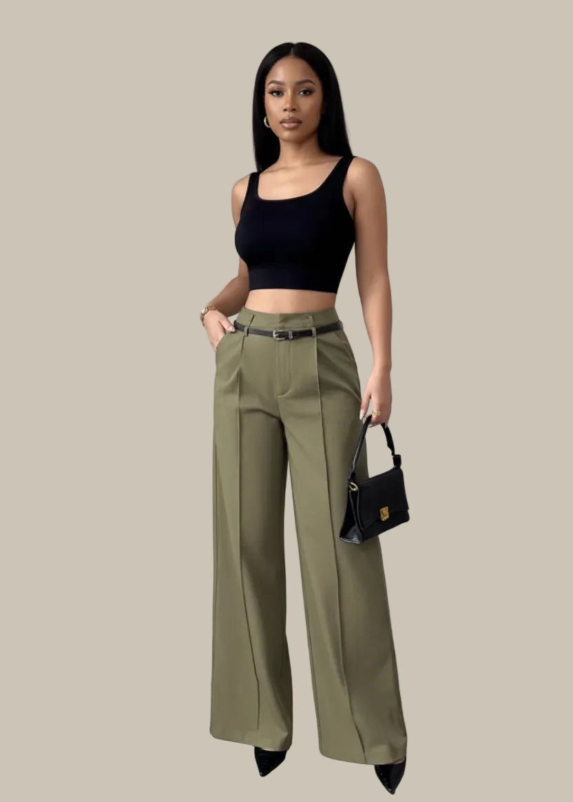 Person wearing olive green wide-leg pants with a black top and handbag against a neutral background